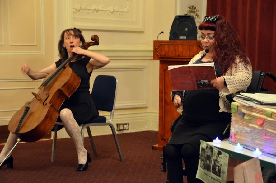 Joanne pulls a shocked face as she plays cello with Penny Pepper, storyteller.