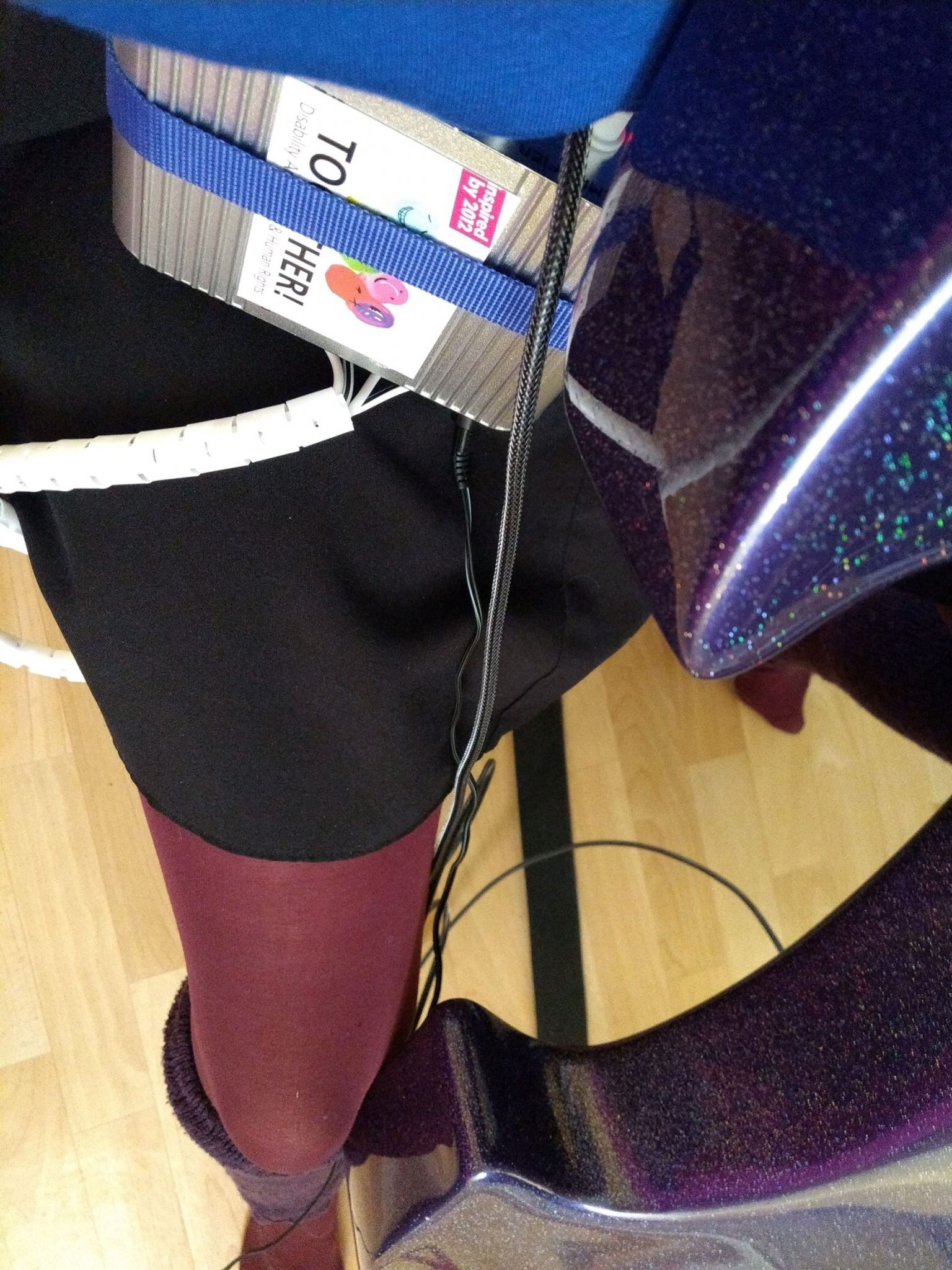 close up shot of  purple sparkly cello, connected via a DI box to a wearable sound tabard