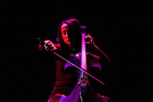 Joanne is bathed in red and purple light as she plays with intensity